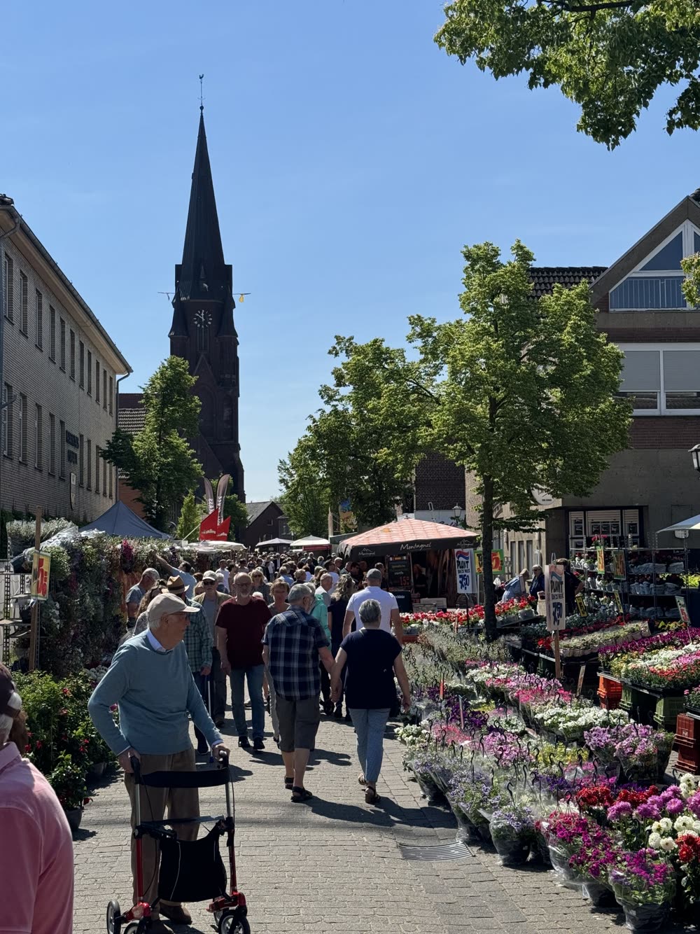 Besucher beim Frühlingsfest in der Olfener Innenstadt, im Hintergrund der Kirchturm von St. Vitus